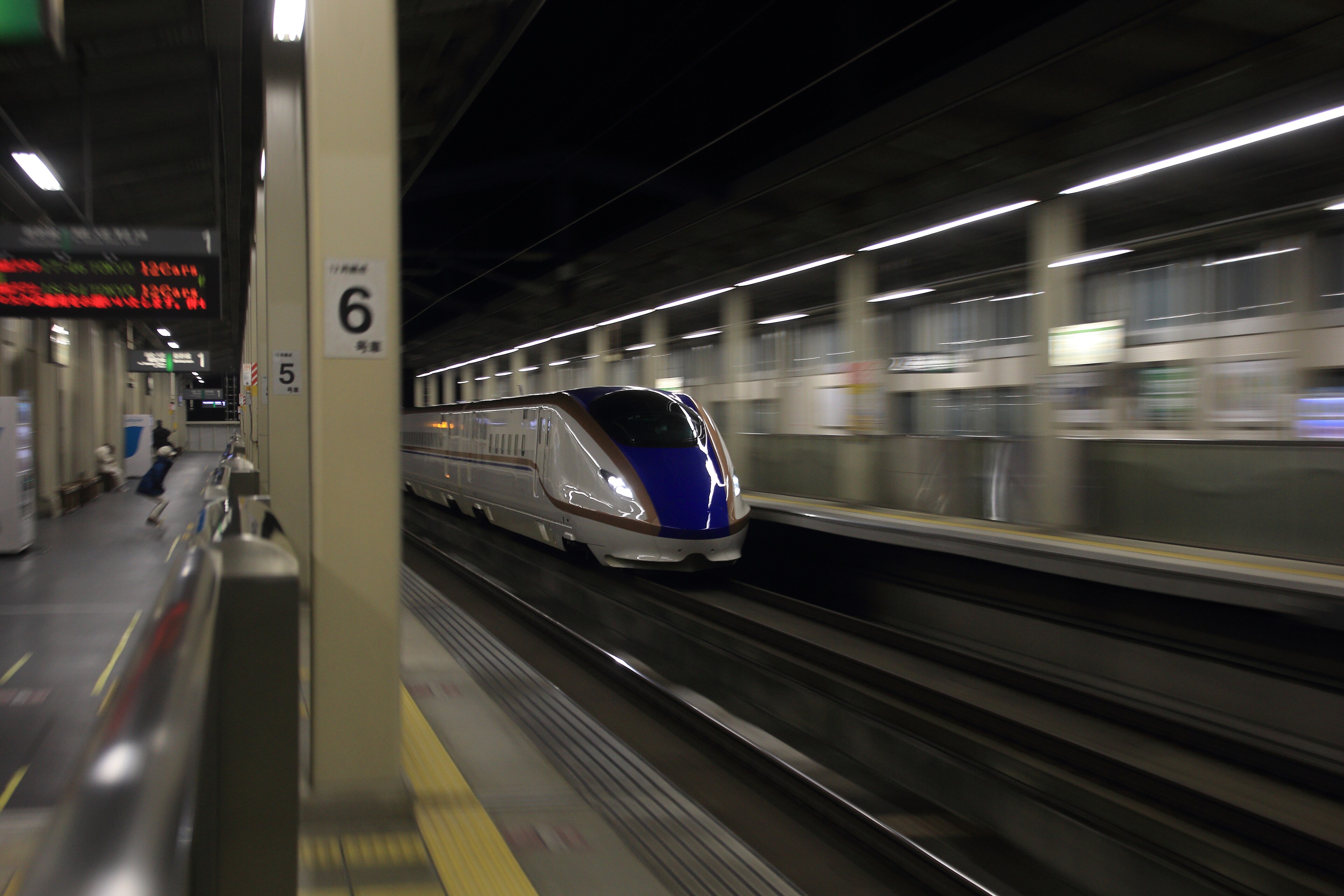 An E7 series Shinkansen passing through the platforms of Ueda Station in Nagano Prefecture